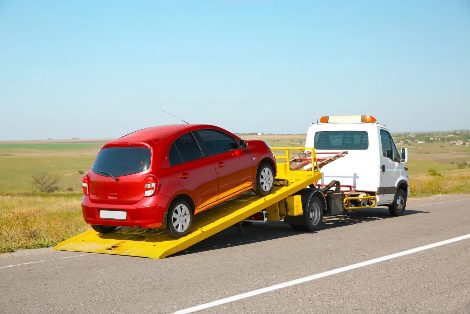 Rapid Car Recovery tow truck loading a vehicle in Sharjah